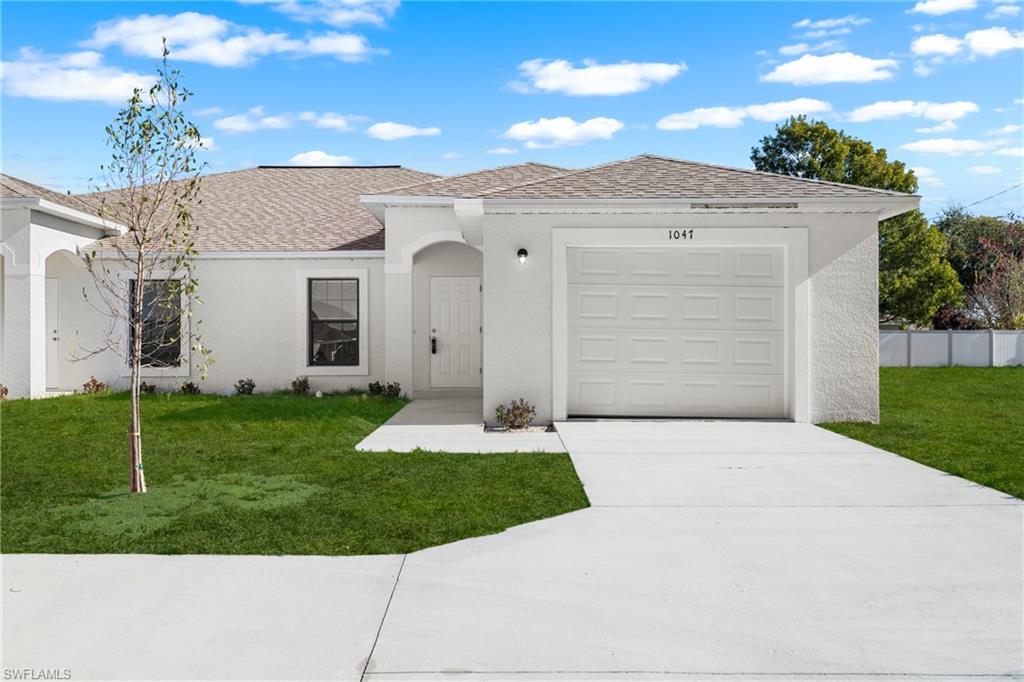 Front exterior featuring a stucco finish, attached garage, and a concrete driveway