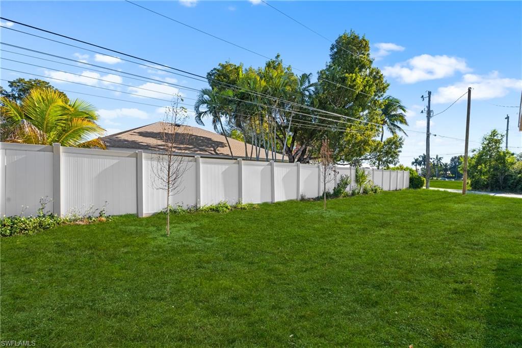 Expansive green lawn bordered by a white privacy fence