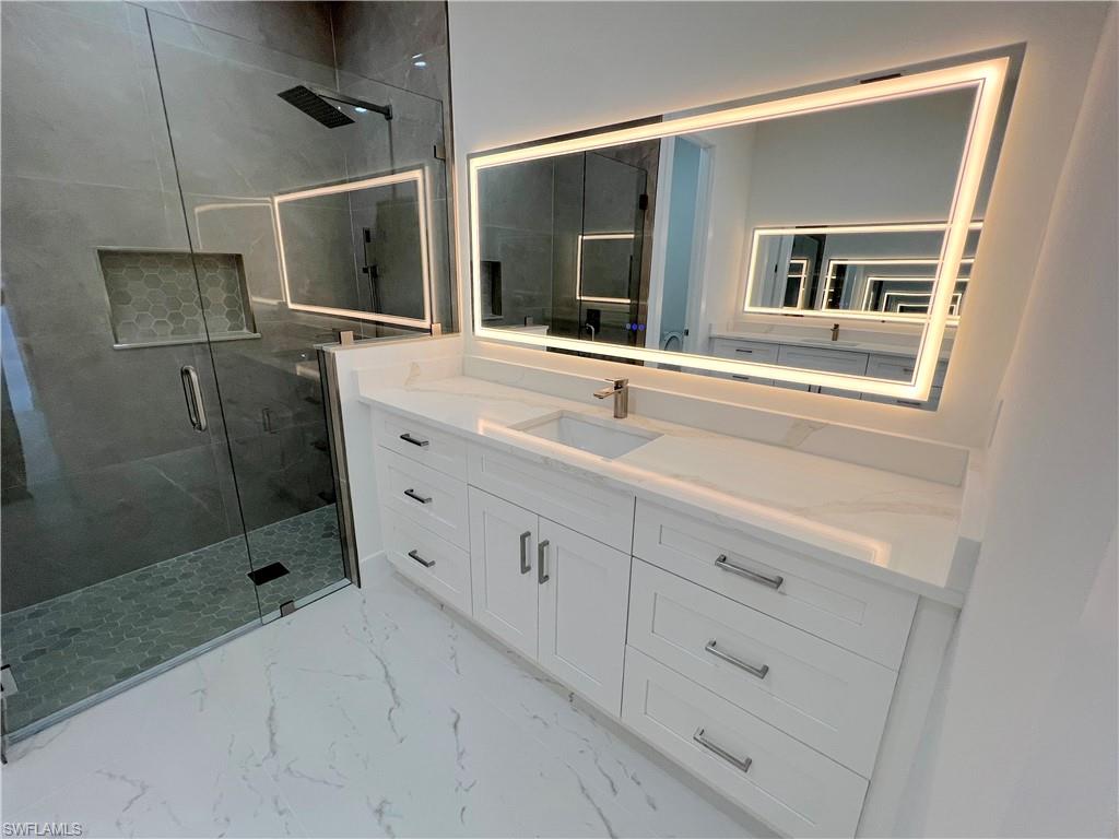 One of two large vanities with backlit mirrors in the primary bathroom.