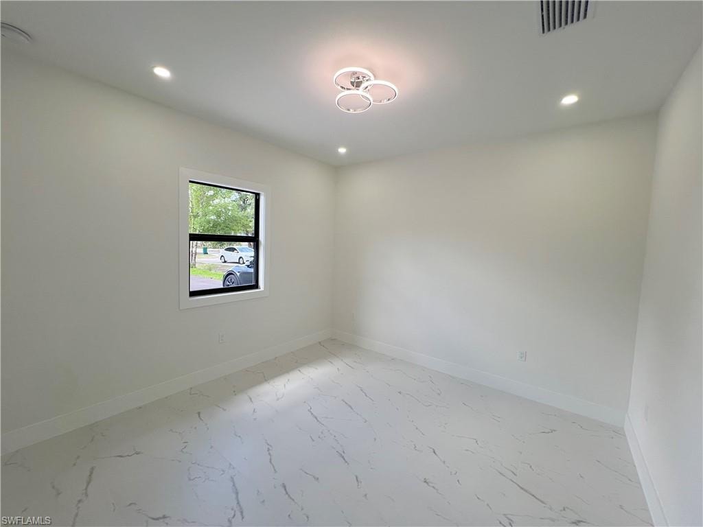 Spacious extra room with door. This room is in addition to the 3 beds. It can be used as an office, den, guest bed etc. It features light-colored walls, recessed ceiling lighting, a modern central fixture, white baseboards, and marble-look flooring