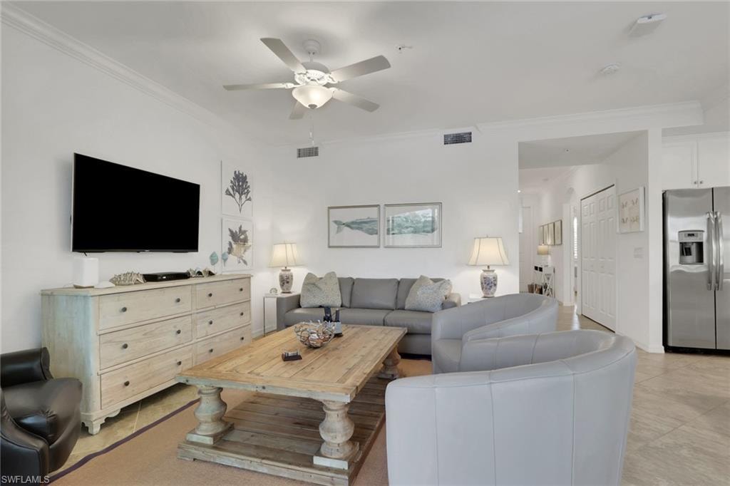 Bright living area featuring crown molding, a ceiling fan with integrated lighting, and neutral wall tones