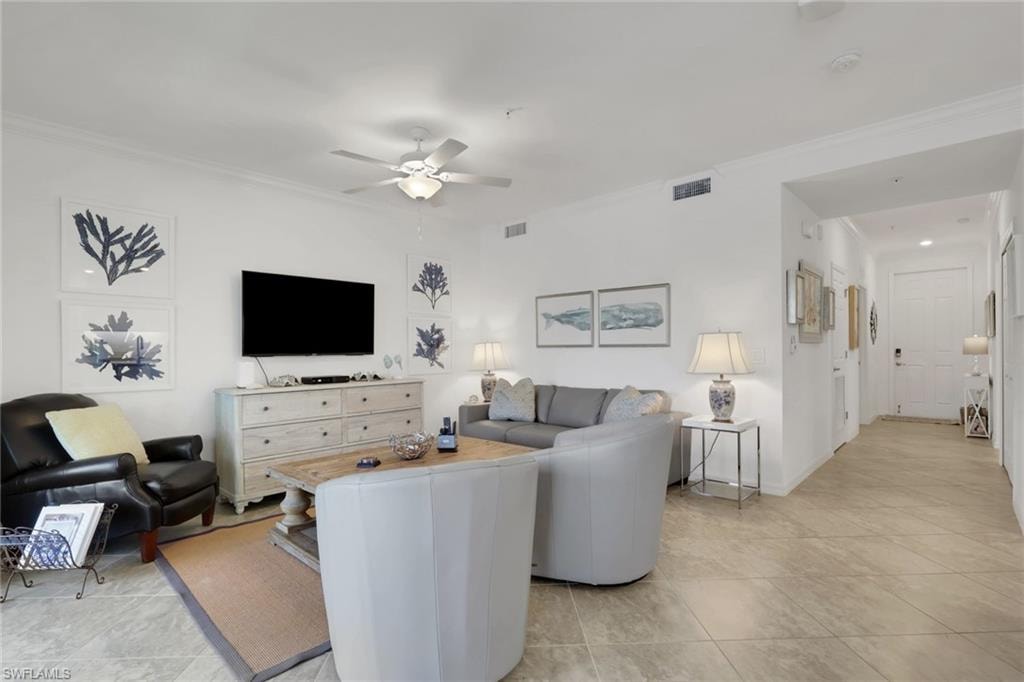 Living area featuring light-toned tile flooring, white walls, and crown molding