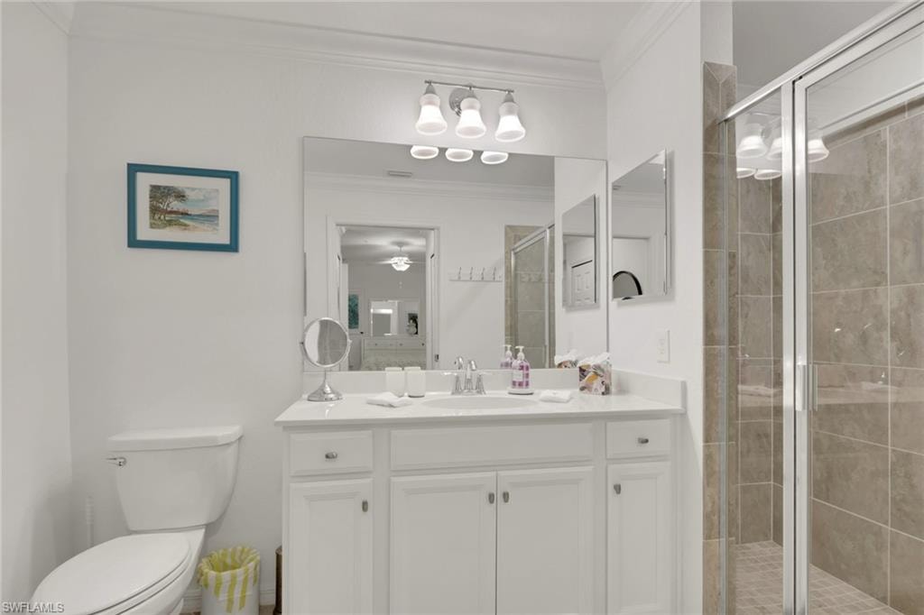 Bathroom with white vanity cabinetry, integrated sink, and a large mirror