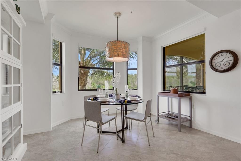 Dining area featuring multiple windows, tiled flooring, and crown molding