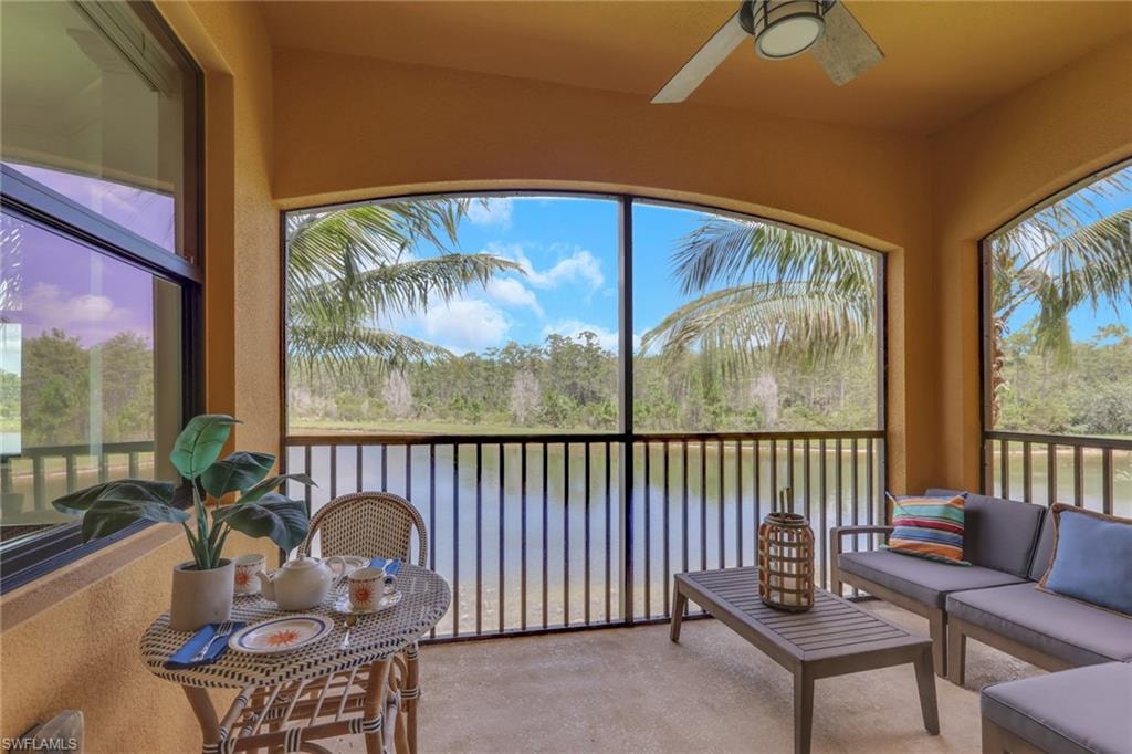 Screened lanai featuring a ceiling fan, concrete flooring, and water views