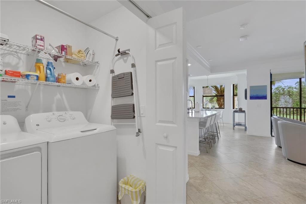 Dedicated laundry area featuring a white top-loading washing machine, white front-loading dryer, and overhead wire shelving