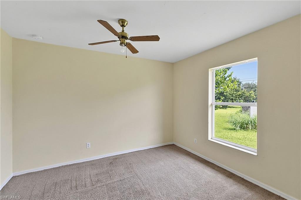Carpeted room with neutral wall color and white trim