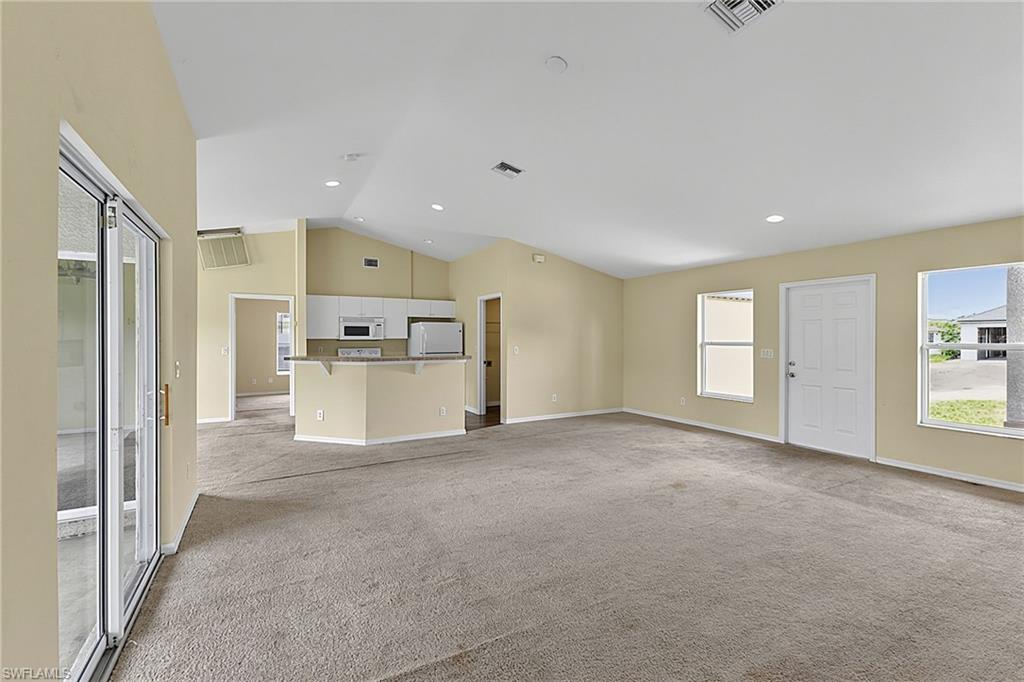 Spacious interior featuring a vaulted ceiling and recessed lighting