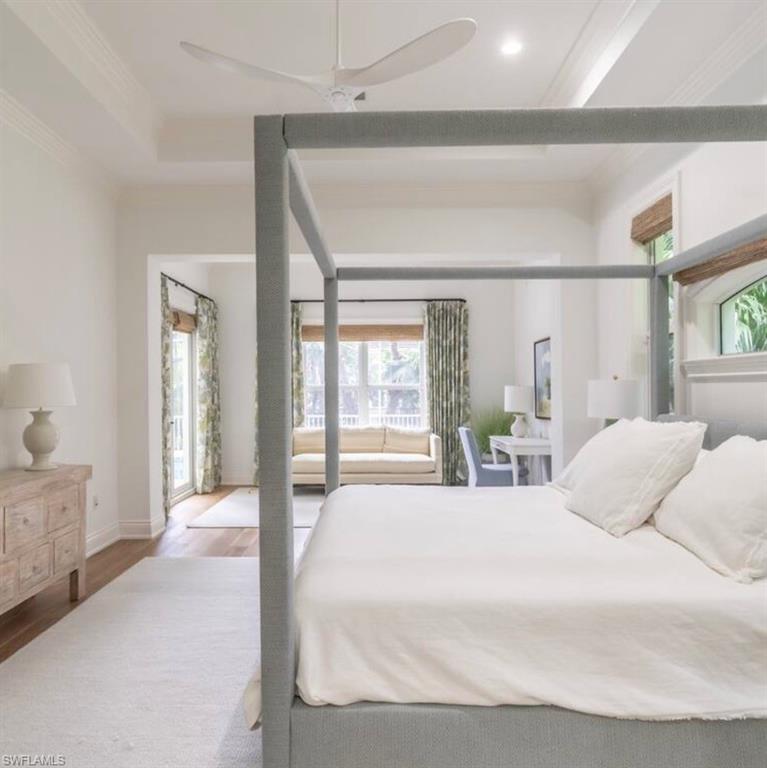 Bedroom with wood finished floors, crown molding, and ceiling fan