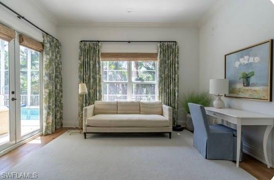 Living area featuring light wood-style flooring and crown molding
