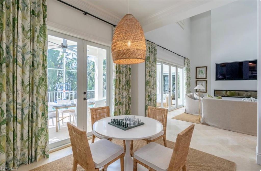 Dining room featuring french doors, ornamental molding, a high ceiling, and a ceiling fan