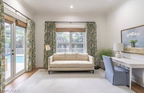 Sitting room with plenty of natural light, wood finished floors, french doors, and recessed lighting