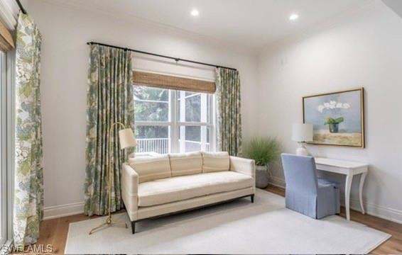 Sitting room with wood finished floors, recessed lighting, and crown molding