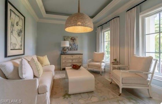 Sitting room featuring a tray ceiling and crown molding