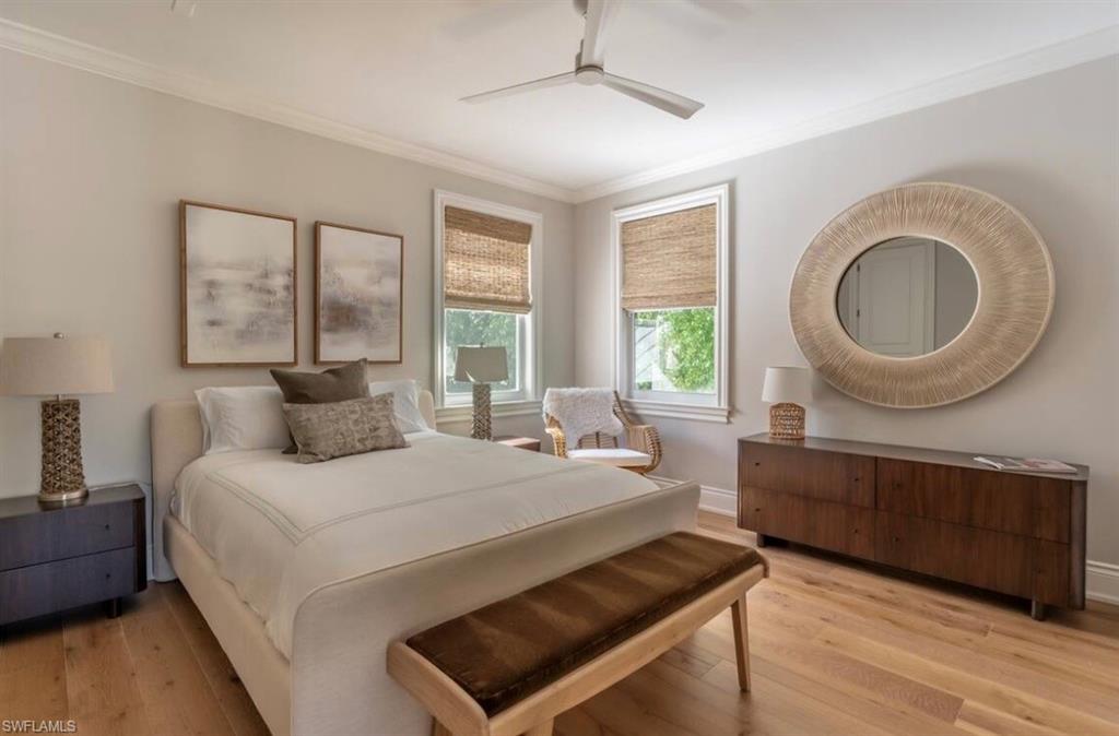 Bedroom with crown molding, light wood-style flooring, and a ceiling fan