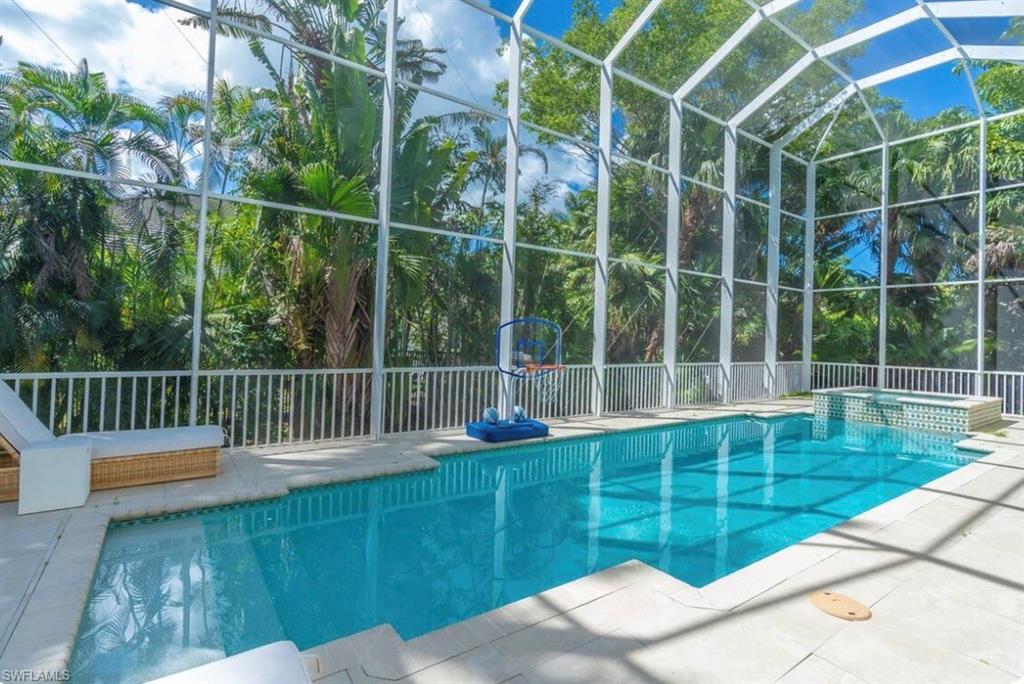 Relaxing pool / spa featuring a lanai and a patio area