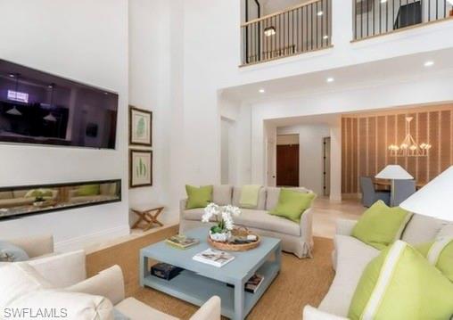 Living area with a high ceiling and suspended lighting