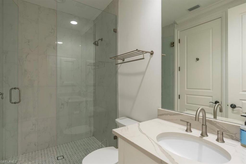 Full bathroom with vanity and a marble finish shower