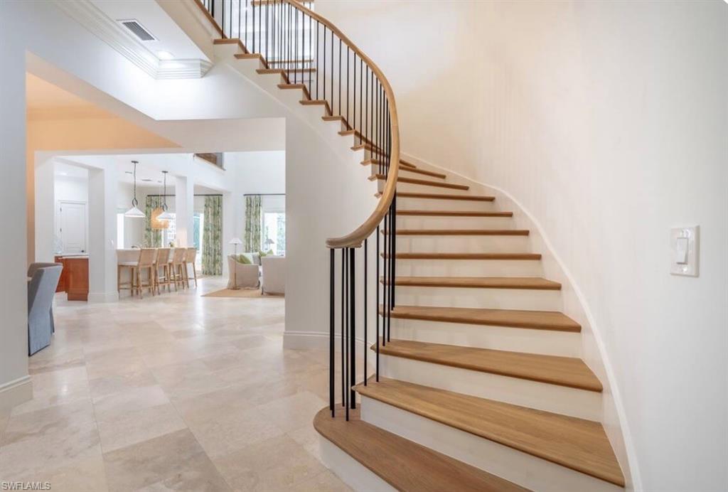 Stairway featuring crown molding and a high ceiling