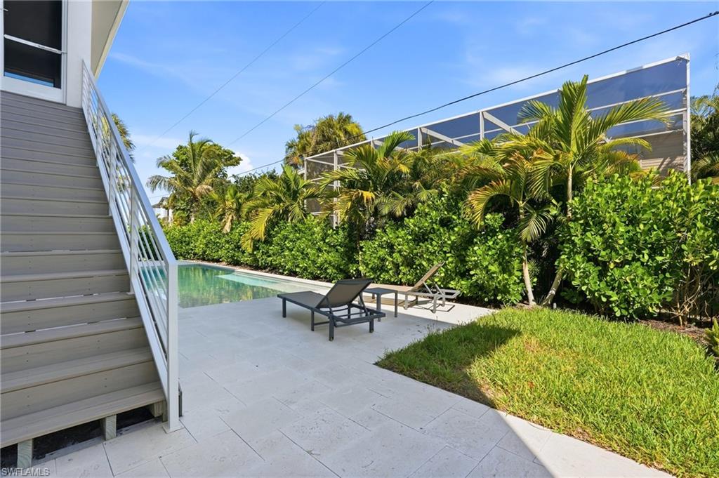 Outdoor pool featuring a patio area and stairs. virtually edited photo