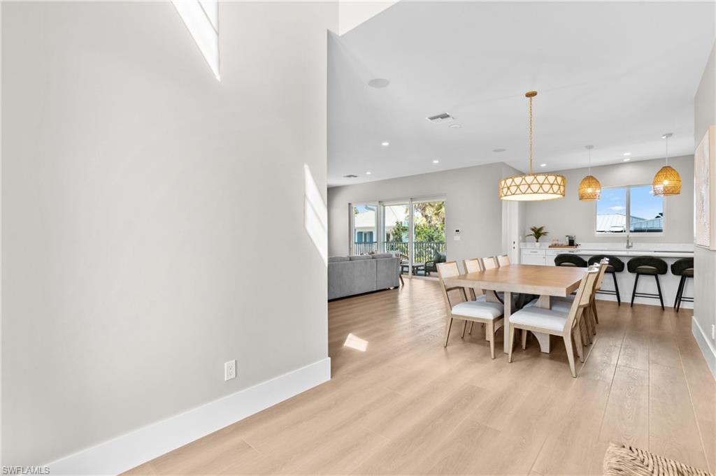 Dining area featuring recessed lighting, light wood-type flooring, visible vents, and baseboards. virtually edited photo
