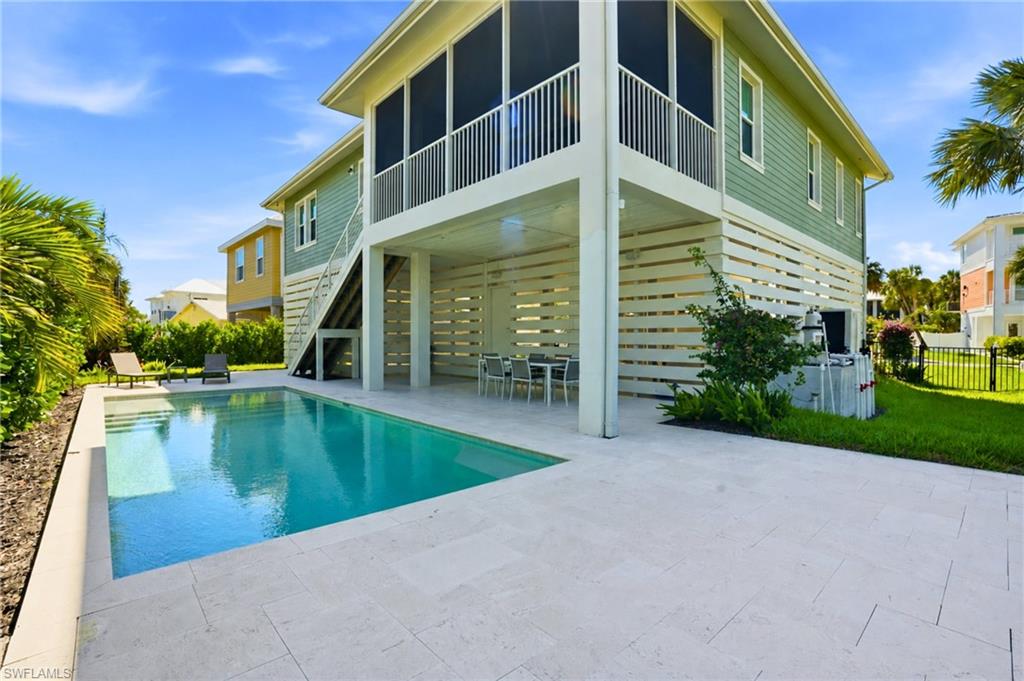LET'S GO SWIMMING -Rear view of property with fence, a patio, a fenced in pool, a sunroom, and stairs. virtually edited photo