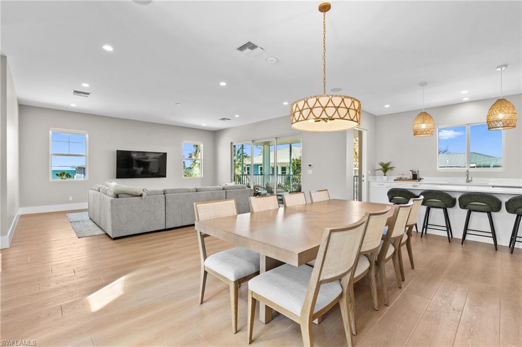 Dining room with recessed lighting, a wealth of natural light, visible vents, and light wood-type flooring. virtually edited photo