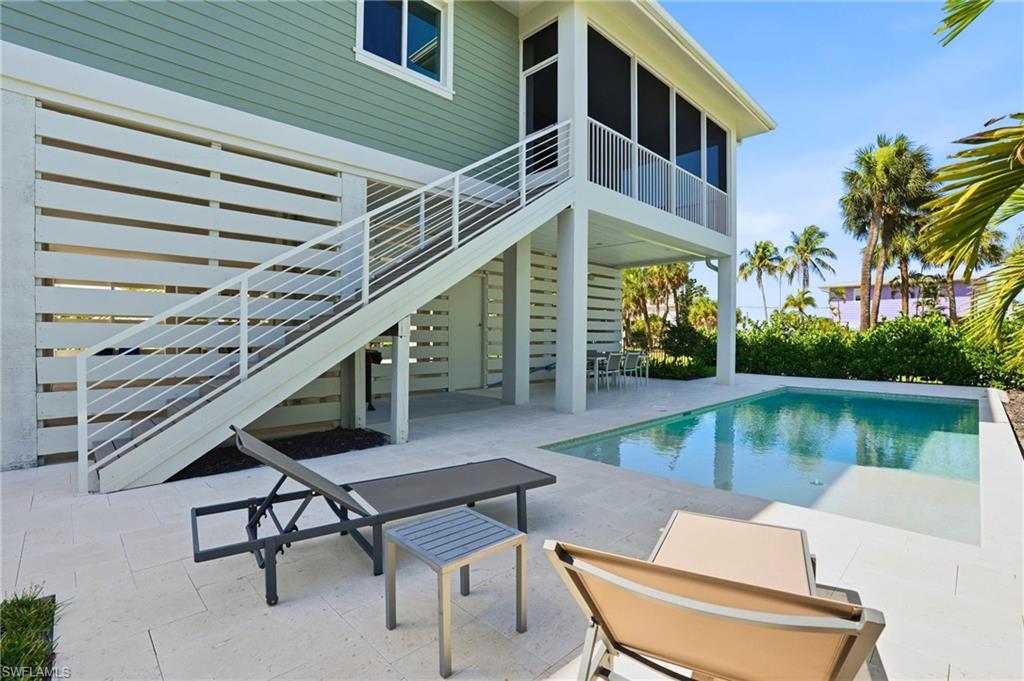LAZY DAYS by the POOL - View of swimming pool with a patio area, fence, a fenced in pool, a sunroom, and stairs. virtually edited photo