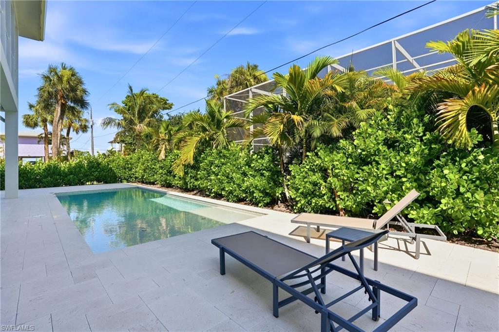 Rectangular in-ground pool surrounded by light-toned paver decking