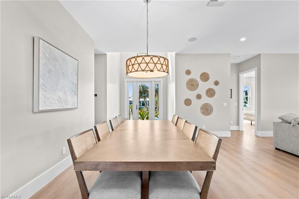 Dining space featuring light wood-type flooring, baseboards, and recessed lighting. virtually edited photo