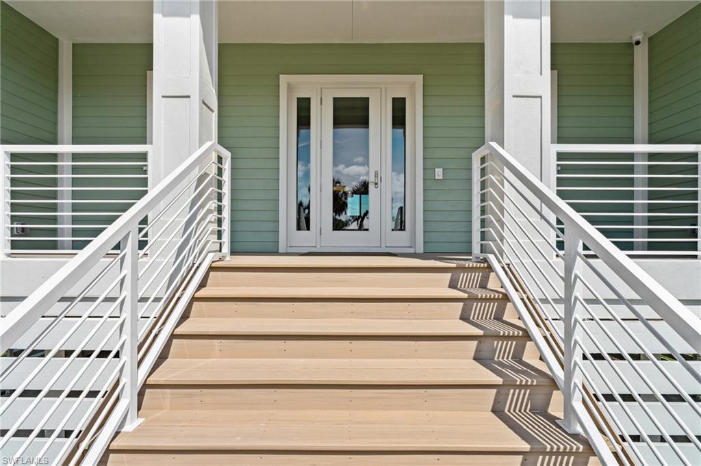 Doorway to property featuring a porch. virtually edited photo