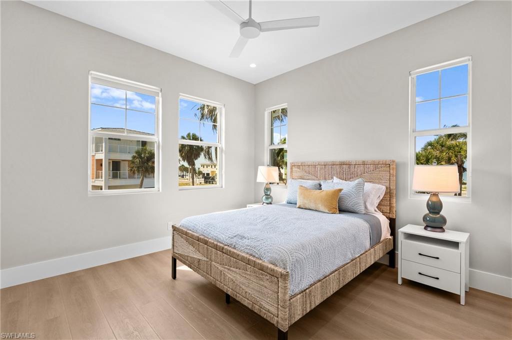 Bedroom with recessed lighting, wood finished floors, a ceiling fan, and baseboards. virtually edited photo