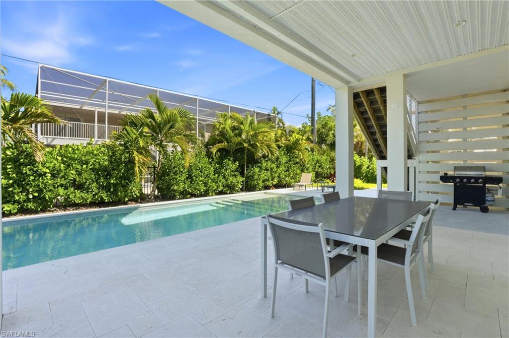 Outdoor pool featuring a patio area and stairs. virtually edited photo