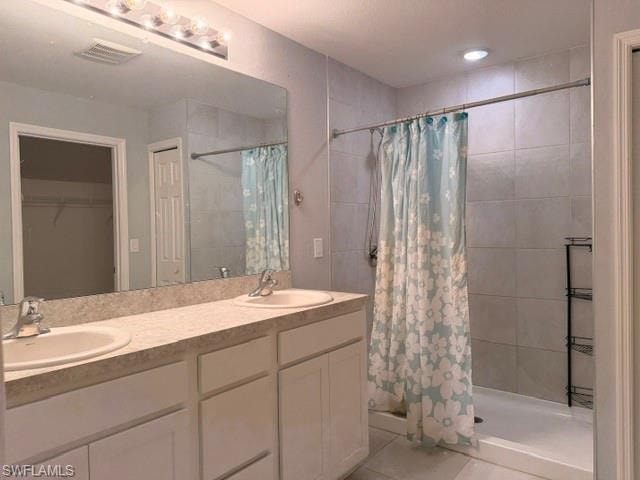 Dual vanity with laminate countertop, integrated sinks, white cabinetry, and an expansive wall mirror