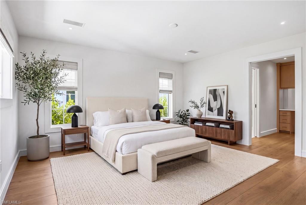 he luxurious primary suite offers a spa-like ensuite complete with Kohler fixtures, a marble vanity, and a frameless glass-enclosed tile shower. The custom-designed walk-in closet includes built-in cabinetry and a dedicated desk or makeup vanity. (Furniture is virtually staged in this photo).