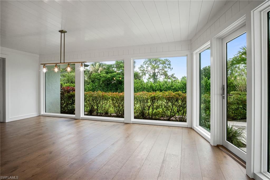 Gorgeous sunlit dining room or sun room with floor to ceiling windows/doors & spectacular lush green nature views.