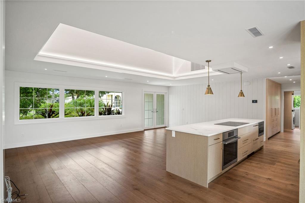Gorgeous vaulted ceiling accent with custom wood paneling & cove lighting. Gorgeous greenery & natural light throughout.