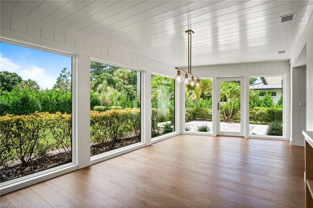 Gorgeous sunlit dining room or sun room with floor to ceiling windows/doors & spectacular lush green nature views.