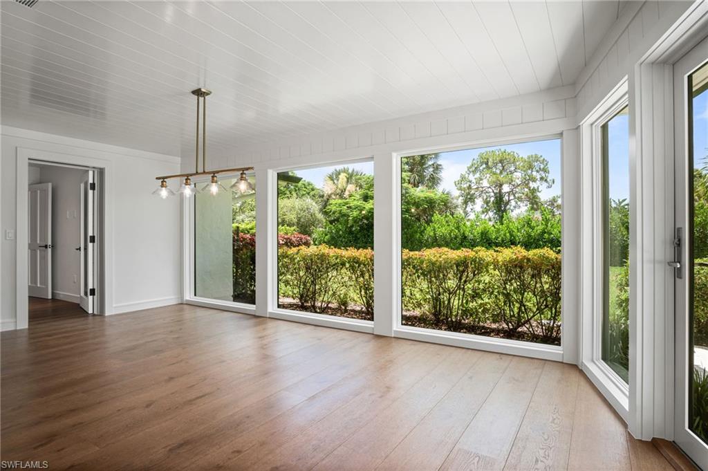 Gorgeous sunlit dining room or sun room with floor to ceiling windows/doors & spectacular lush green nature views.