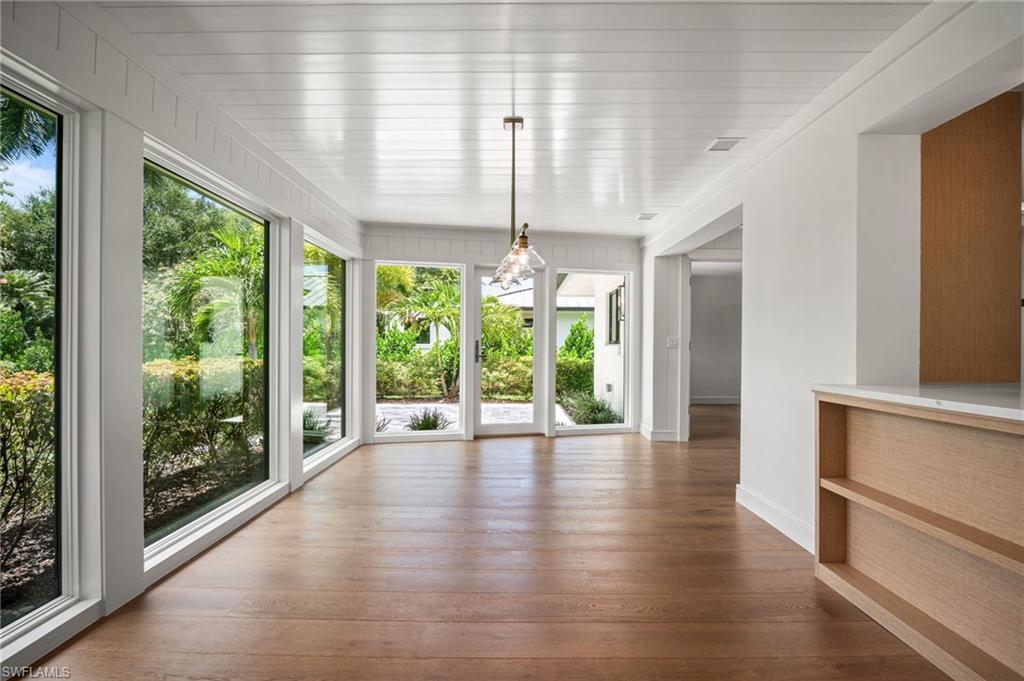 Gorgeous sunlit dining room or sun room with floor to ceiling windows/doors & spectacular lush green nature views.