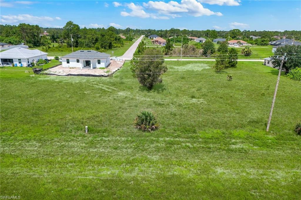 Spacious green lot featuring an adjacent new construction home