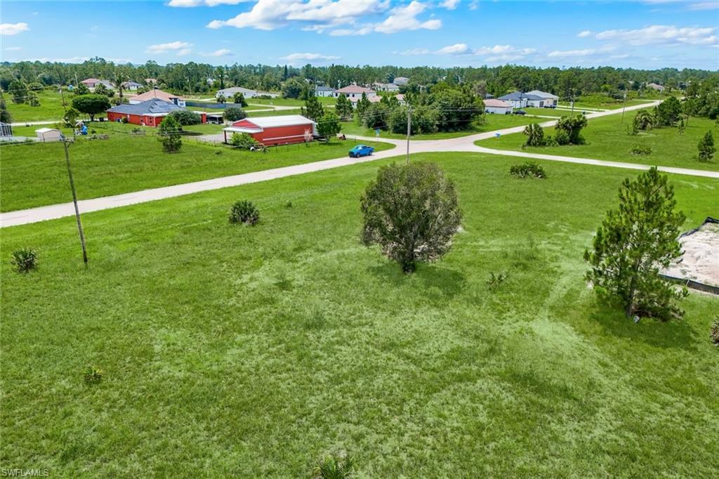 Expansive, undeveloped green land featuring scattered trees and a clear perimeter