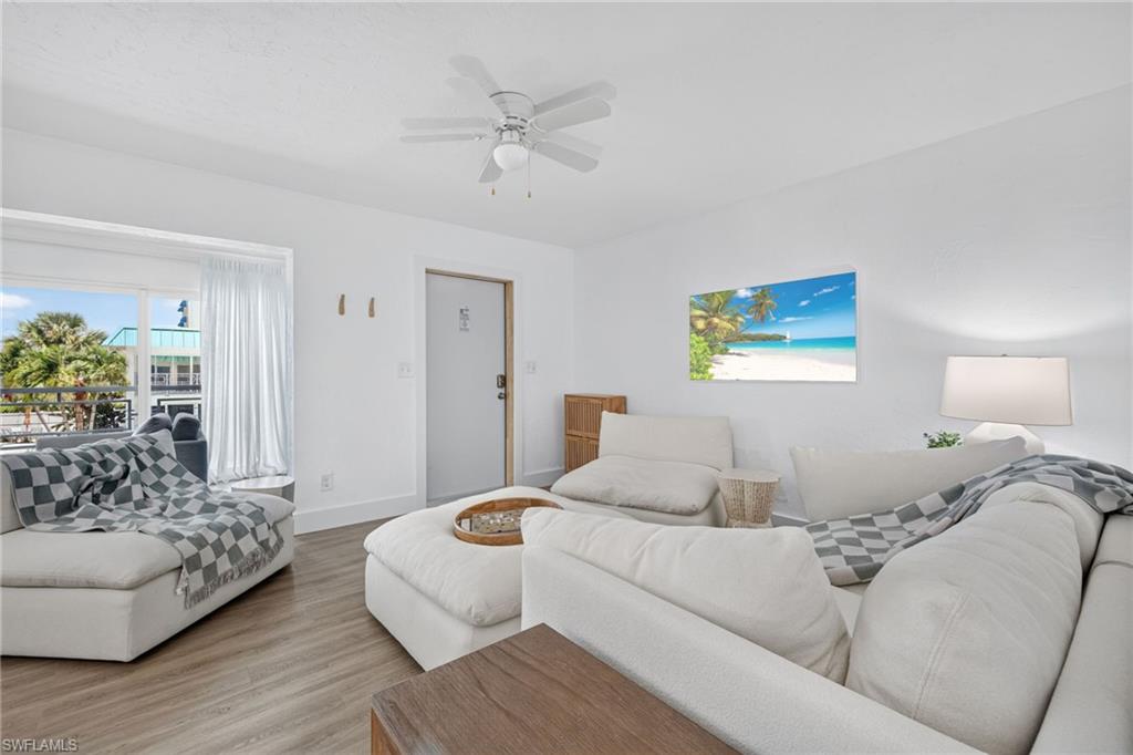 Bright interior space featuring a ceiling fan, wood-finish flooring, and a window with exterior views