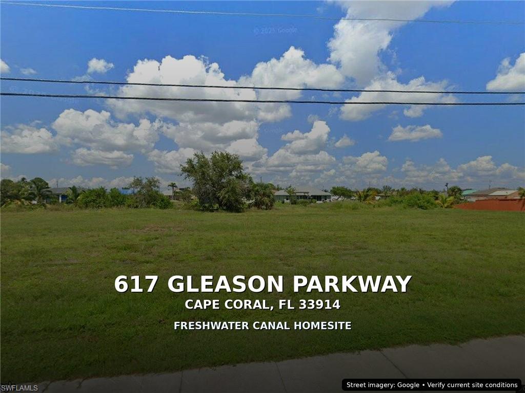 Expansive cleared lot featuring green grass and a clear blue sky