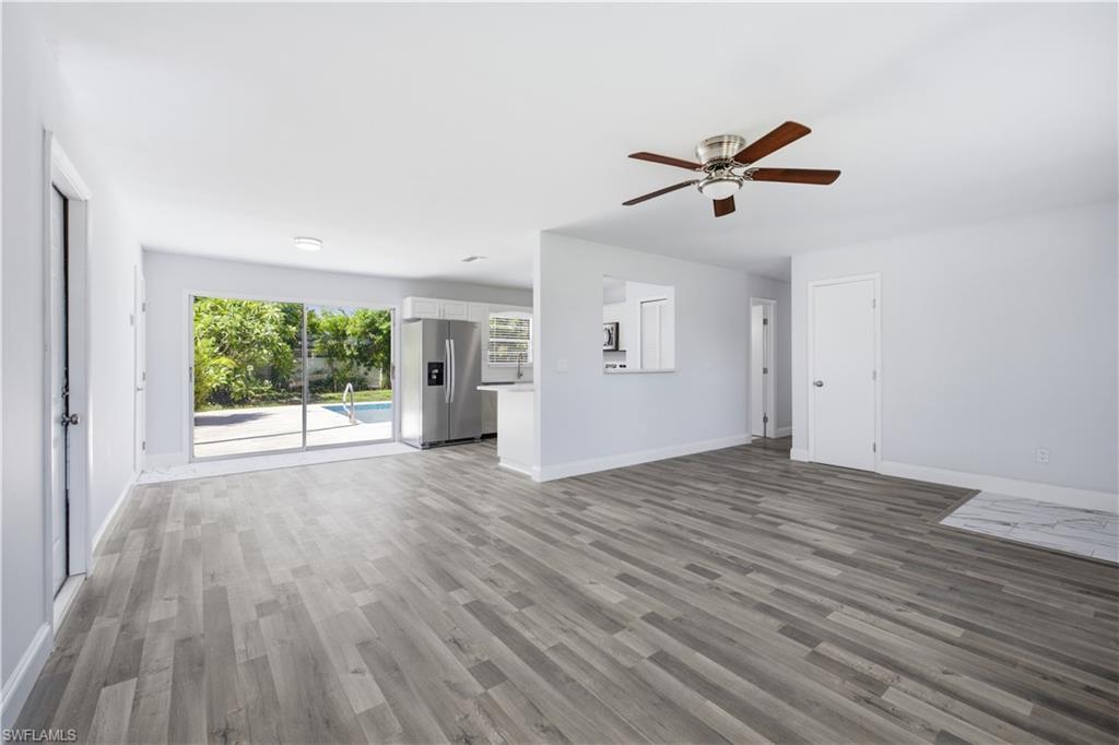 Open-concept living area featuring wood-finish flooring and a ceiling fan with integrated lighting