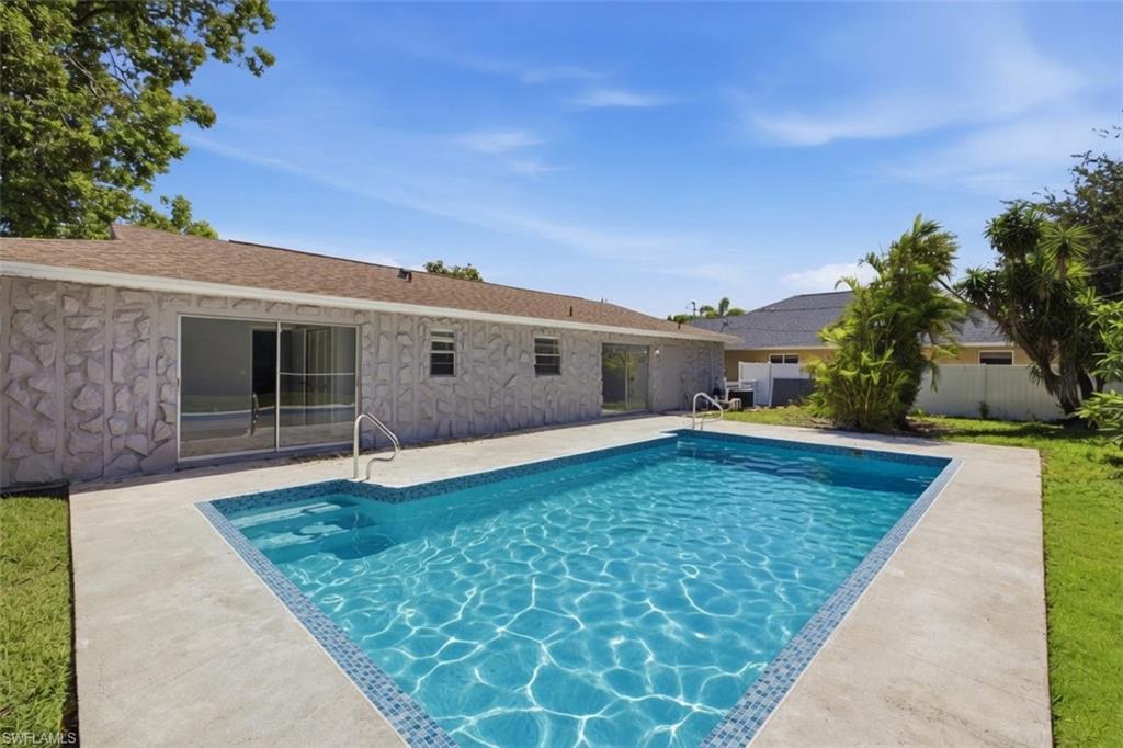 Rectangular swimming pool with tiled steps and integrated handrails