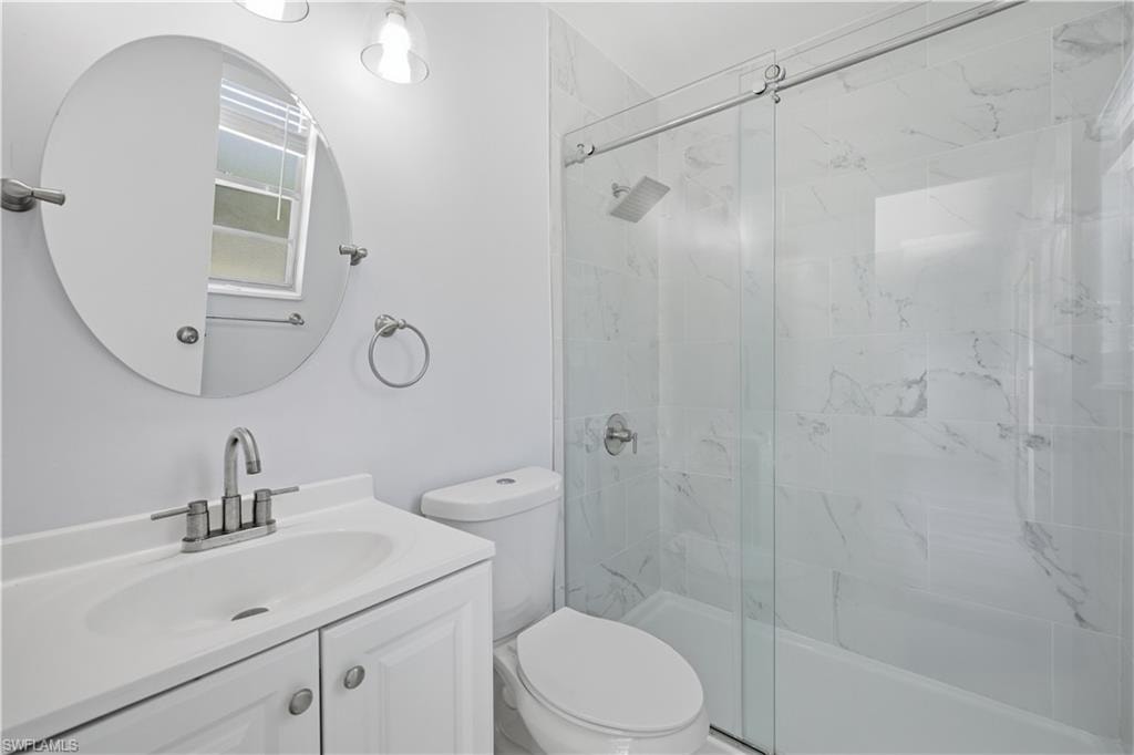 Bathroom featuring a white vanity with integrated sink, chrome faucet, and oval mirror