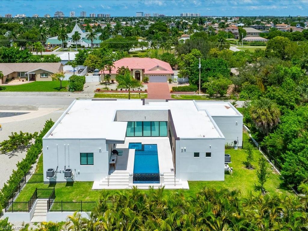 Modern architecture featuring a central courtyard with a swimming pool, multiple outdoor entertaining areas, and a spacious green lawn
