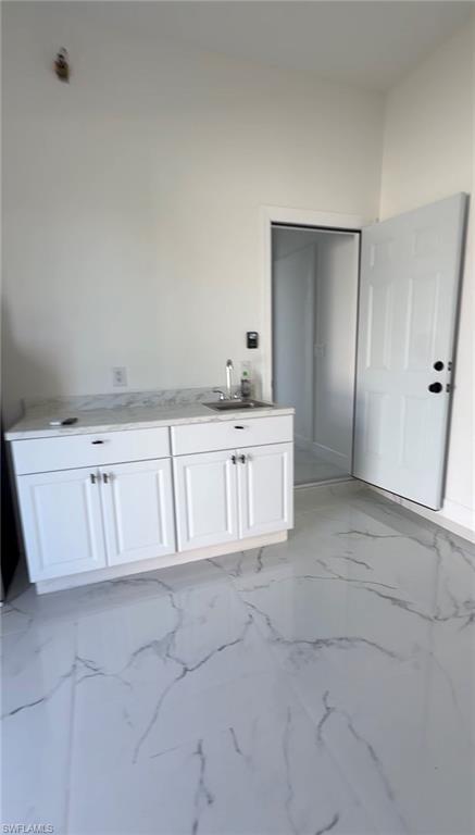 Bathroom with light marble finish flooring and vanity