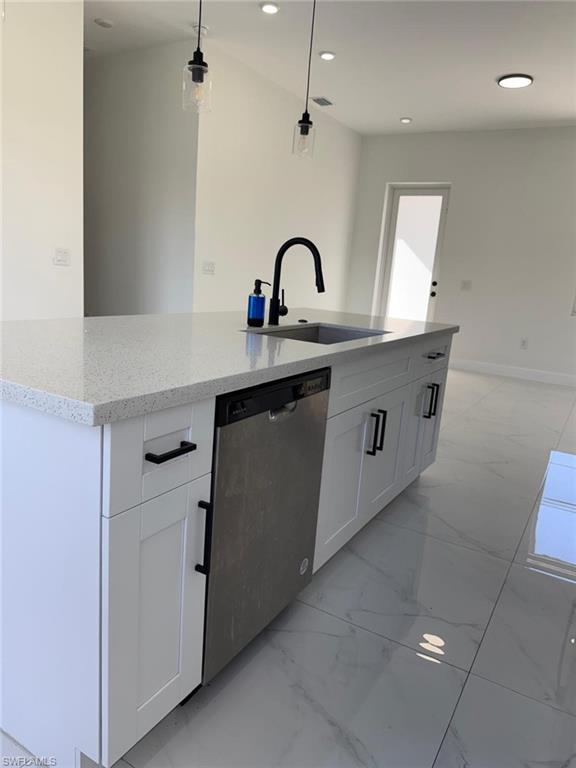 Kitchen with light marble finish flooring, white cabinetry, dishwasher, light stone countertops, and pendant lighting